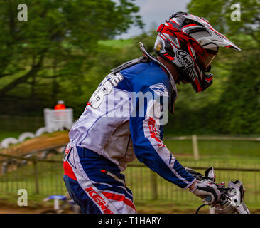 British motocross championship racing at Cadders Hill, Lyng, Norfolk. Motocross rider standing up ready for an up and coming jump. Stock Photo