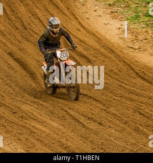 British motocross championship racing at Cadders Hill, Lyng, Norfolk. Negotiating not only the steep hill descent but also the deep ruts carved in to  Stock Photo