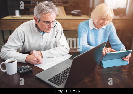 Old enterpreneur and his partner are working together on differe Stock Photo