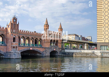 Banks of the river Spree with  a part of the Brick Gothic viaduct Oberbaum Bridge with its wall-walks and towers. View from the river. Stock Photo