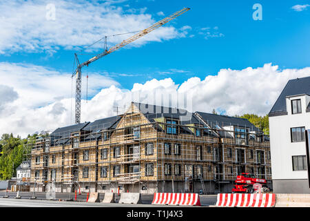 Akureyri, Iceland - June 17, 2018: Street view in large town fishing village by fjord and construction on building with crane and blue sky Stock Photo