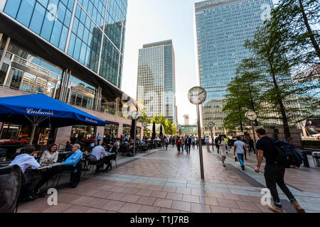 London, UK - June 26, 2018: People commuters outside metro entrance during morning commute in Canary Wharf Docklands with modern architecture and rest Stock Photo