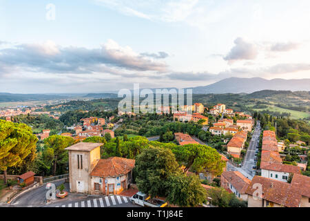 Chiusi sunset evening in Umbria, Italy with rooftop houses on mountain countryside rolling hills and street road with colorful picturesque cityscape w Stock Photo