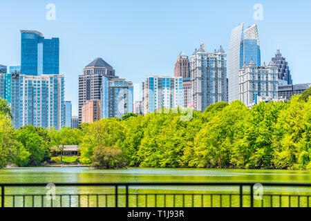 Atlanta, USA - April 20, 2018: Cityscape skyline view in Piedmont Park in Georgia downtown green trees, scenic urban city skyscrapers with railing in  Stock Photo