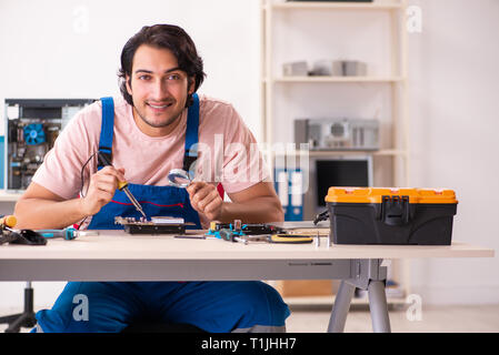 Young male contractor repairing computer Stock Photo