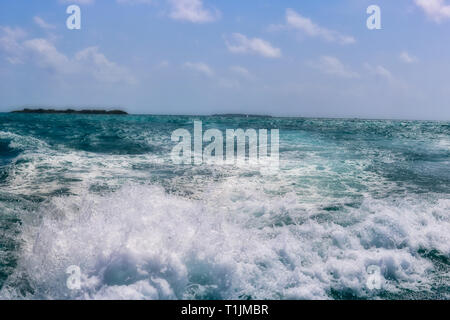 this unique image shows the beautiful turquoise sea with waves and an island in the background. The picture was taken on a moving boat Stock Photo
