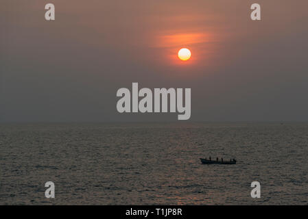 Sunset and fishing boat seen from Anjuna Beach,Goa,India,Asia Stock Photo