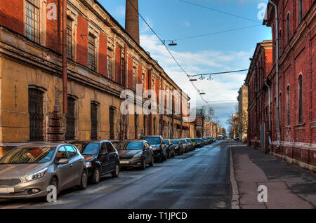 Old grunge street in Russian town with parked cars Stock Photo