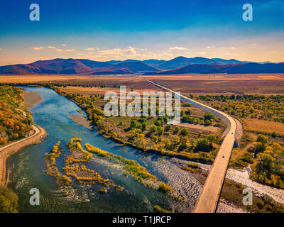 Aerial photograph of meandering river against mountains and grasslands with blue skies in autumn in inner Mongolia, china Stock Photo