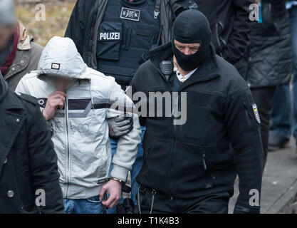 Wiesbaden, Germany. 27th Mar, 2019. Accompanied by masked police officers, Ali B., accused of murdering 14-year-old Susanna, is led along a railway line near Erbenheim. Here the man, who came from Iraq, allegedly raped the girl, then killed her and buried her body. Credit: Boris Roessler/dpa/Alamy Live News Stock Photo