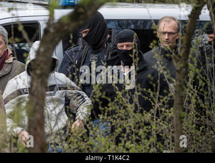 Wiesbaden, Germany. 27th Mar, 2019. Accompanied by masked police officers, Ali B., accused of murdering 14-year-old Susanna, is led along a railway line near Erbenheim. Right Judge Jürgen Bonk. Here the man, who came from Iraq, allegedly raped the girl, then killed her and buried her body. Credit: Boris Roessler/dpa/Alamy Live News Stock Photo