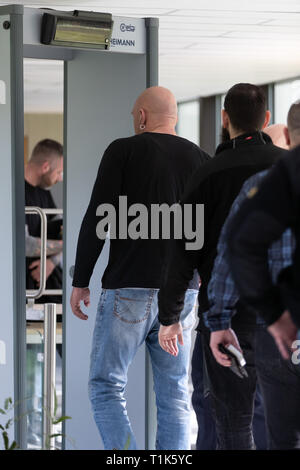 Bielefeld, Germany. 27th Mar, 2019. Visitors to the trial go through the security check at the district court. A trial against eight men on suspicion of a serious breach of the peace begins under great security precautions. The defendants, aged between 20 and 38, are to belong to an extended family. After an argument, one of the men was expelled from a discotheque. The 27-year-old is said to have called his brother and other relatives to it. The argument escalated. Credit: Friso Gentsch/dpa/Alamy Live News