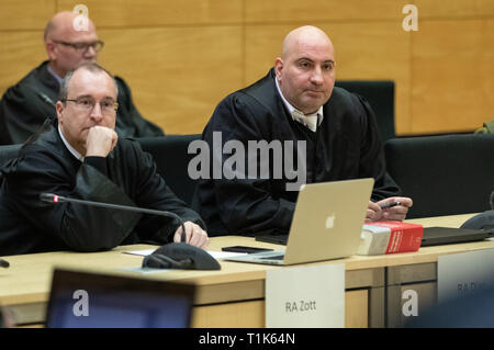 Bielefeld, Germany. 27th Mar, 2019. The defenders of the accused, Andreas Zott (l) and Paulo Dias (r), sit in a hall of the district court. A trial against eight men on suspicion of a serious breach of the peace begins under great security precautions. The defendants, aged between 20 and 38, are to belong to an extended family. After an argument, one of the men was expelled from a discotheque. The 27-year-old is said to have called his brother and other relatives to it. The argument escalated. Credit: Friso Gentsch/dpa/Alamy Live News