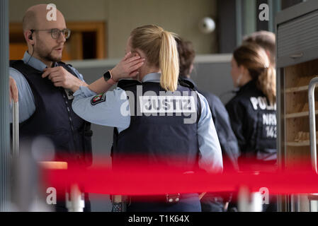 Bielefeld, Germany. 27th Mar, 2019. Judicial officers are standing outside a security perimeter in the county court. A trial against eight men on suspicion of a serious breach of the peace begins under great security precautions. The defendants, aged between 20 and 38, are to belong to an extended family. After an argument, one of the men was expelled from a discotheque. The 27-year-old is said to have called his brother and other relatives to it. The argument escalated. Credit: Friso Gentsch/dpa/Alamy Live News