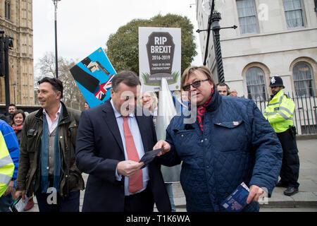 London, UK. 27 March 2019. (L to R) The political activist Andy Wigmore and the  businessman Arron Banks co-founder of the Leave.EU campaign in College Green, Westminster. He discusses with a supporter of the No-Deal campaign. Credit: Santo Basone/Alamy Live News Stock Photo