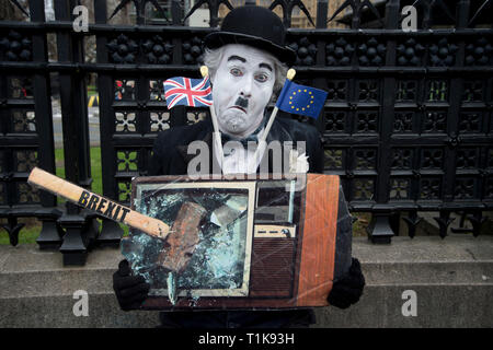 London, UK. 27th Mar, 2019. March 27th 2019 Westminster, Houses of Parliament. A Charlie Chaplin character holds a picture of a television with a hammer saying'Brexit' smashing it'. Credit: Jenny Matthews/Alamy Live News Stock Photo