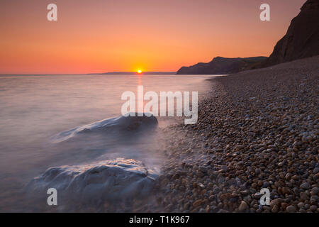 West Bay, Dorset, UK.  27th March 2019.  UK Weather.  Clear skies at sunset at West Bay in Dorset looking west towards the cliffs of Thorncombe Beacon at Eype after another day of warm spring sunshine.  Picture Credit: Graham Hunt/Alamy Live News Stock Photo