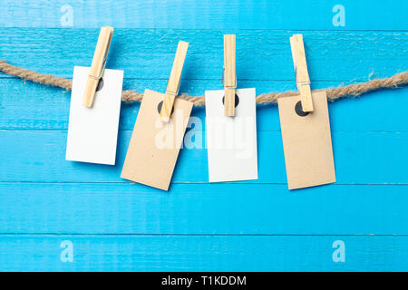 paper attach to rope with clothes pins on wooden background Stock Photo