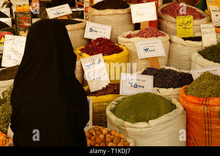 A woman in chador at a herbs shop in a Persian market. Stock Photo