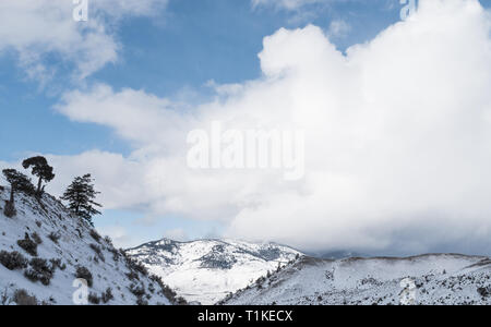 Scenic view of clouds over snow-covered mountains in Yellowstone National Park in winter. Stock Photo