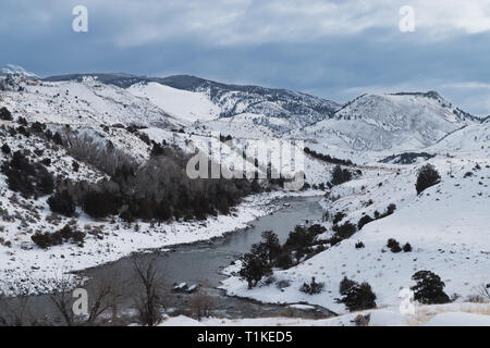 A river flowing between snow-capped mountains in Yellowstone National Park. Stock Photo