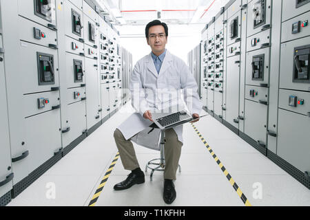 Technical personnel in the voltage room work Stock Photo