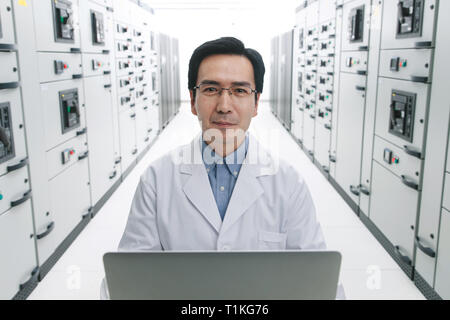 Technical personnel in the voltage room work Stock Photo