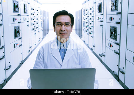 Technical personnel in the voltage room work Stock Photo