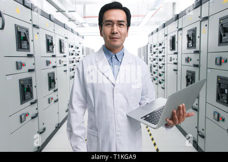 Technical personnel in the voltage room work Stock Photo