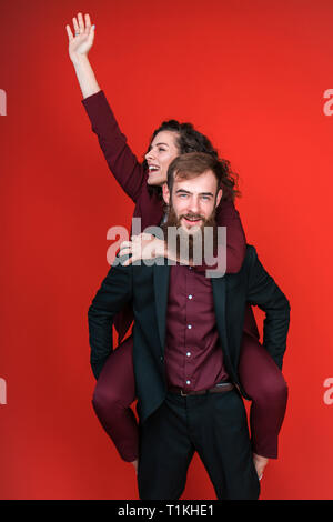 Man carrying woman on back and smiling.