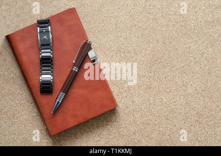Men's accessories notebook, pen, watch, on a cork background. Work, fashion and style. Business concept. Copy space. Stock Photo