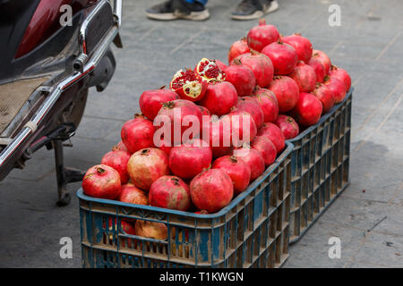 KASHGAR, XINJIANG / CHINA - October 1, 2017: Pomegranates in a plastic box, on display for sale at a market in Kashgar. Stock Photo