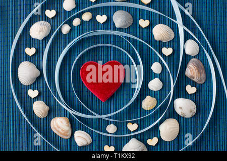 A concept of solar system with red heart in the middle and shells and small wooden hearts around it Stock Photo