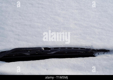 car windscreen wiper covered in snow after snowfall Stock Photo