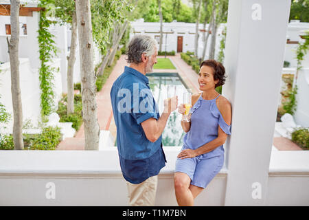 Mature couple drinking mimosas on hotel balcony Stock Photo