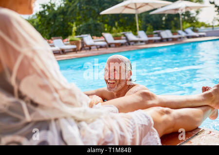 Happy couple relaxing at sunny resort swimming pool Stock Photo