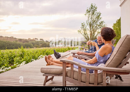 Mature couple toasting champagne flutes on hotel patio Stock Photo