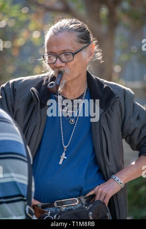 Chinese Man Smoking Pipe in Park Stock Photo