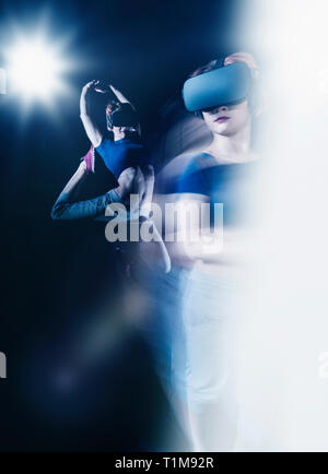 Multiple exposure female modern dancer wearing virtual reality simulator glasses Stock Photo