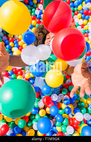 Happy young man playing in vibrant ball pool Stock Photo