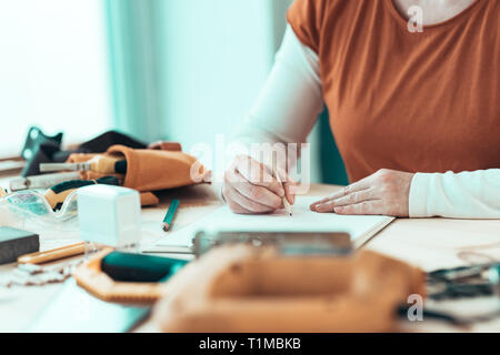 Self employed female carpenter writing project notes on clipboard note paper, selective focus Stock Photo