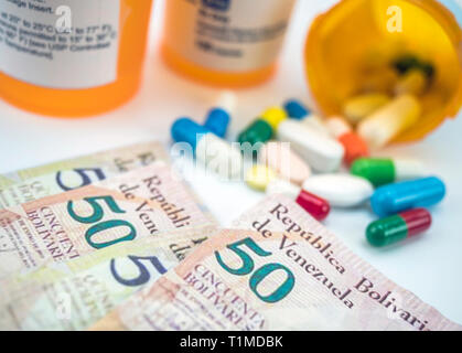 Medicines next to banknotes of Venezuela, shady deal of medication in full crisis of country of Latin America, conceptual image Stock Photo