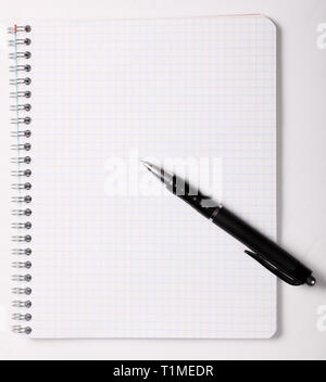 Checked notebook and black pen on white background Stock Photo