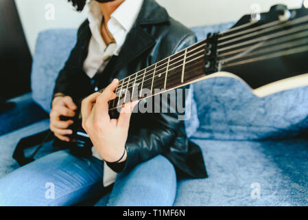 Electric guitar teacher teaching how to place fingers to play a chord. Stock Photo