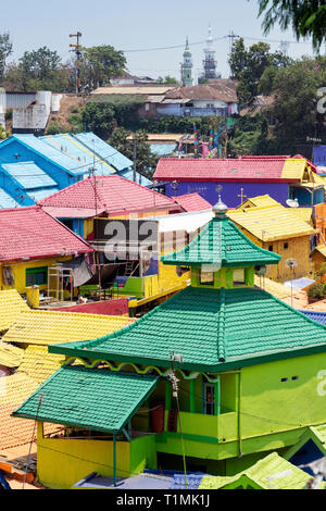 The brightly painted Warna-warni kampong slum in Malang, Java, Indonesia with the community mosque in the foreground Stock Photo