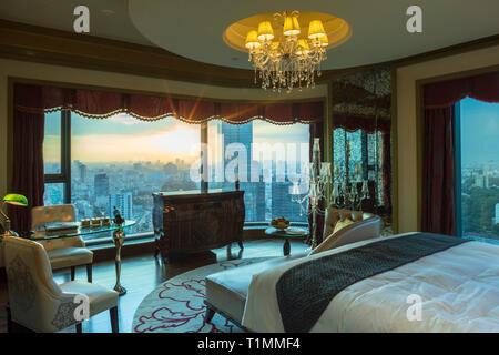 A bedroom in the Reverie Saigon hotel showing the city view from the bed, Ho Chi Minh City, Vietnam Stock Photo