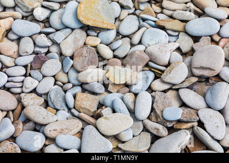 Beach pebble background in various shades of greys, blues, reds and browns. Stock Photo