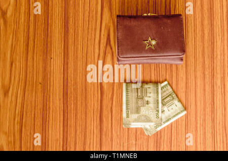 Indian five hundred (500) rupee cash note in brown color wallet leather purse on a wooden table. Business finance economy concept. Side angel view wit Stock Photo