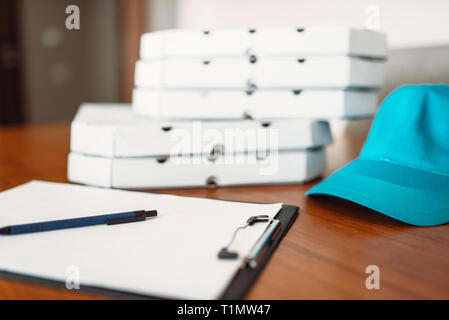 Carton pizza boxes, cap and empty order on table Stock Photo