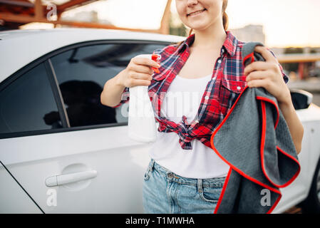 Woman polishes car after washing on car-wash Stock Photo